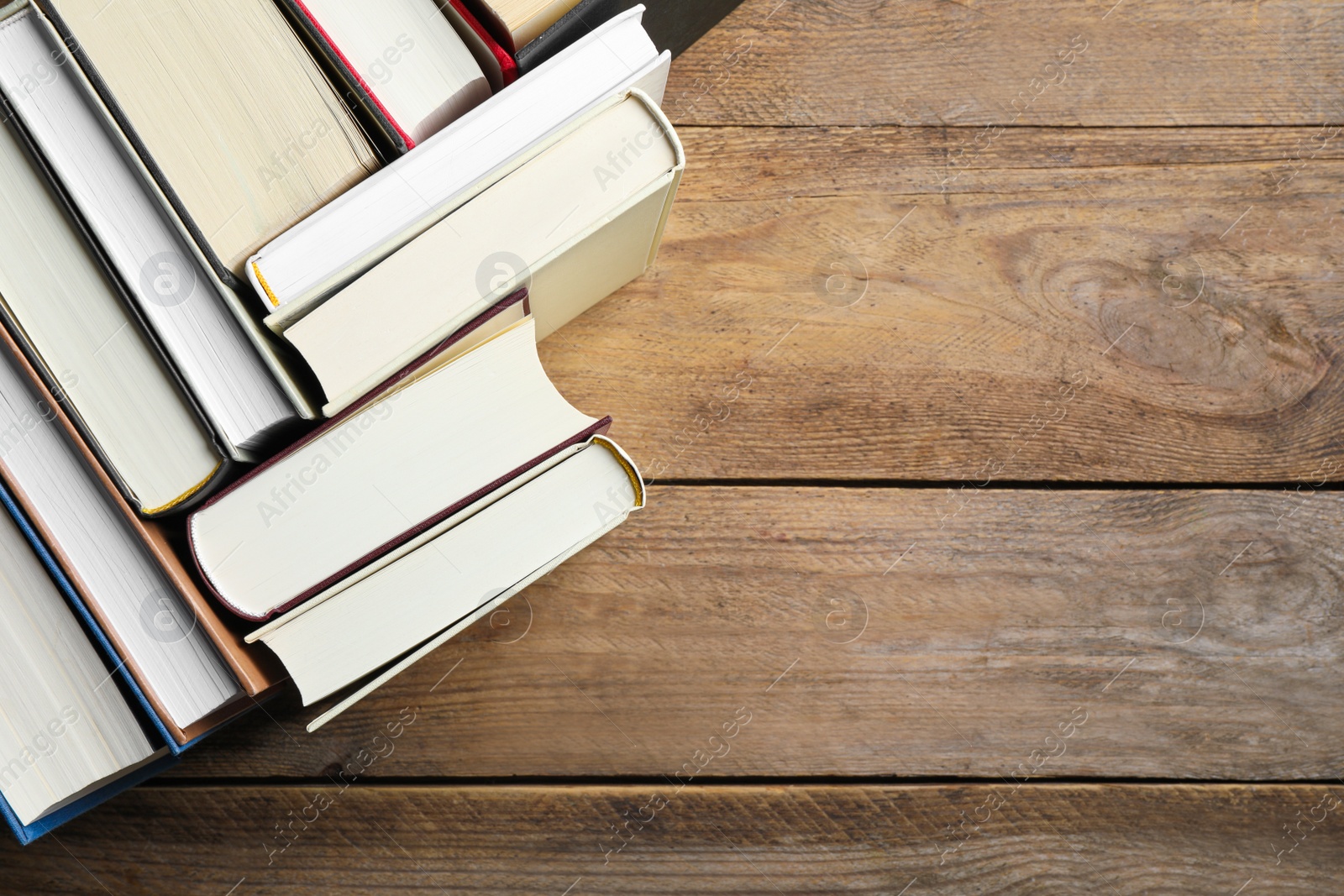 Photo of Hardcover books on wooden table, flat lay. Space for text