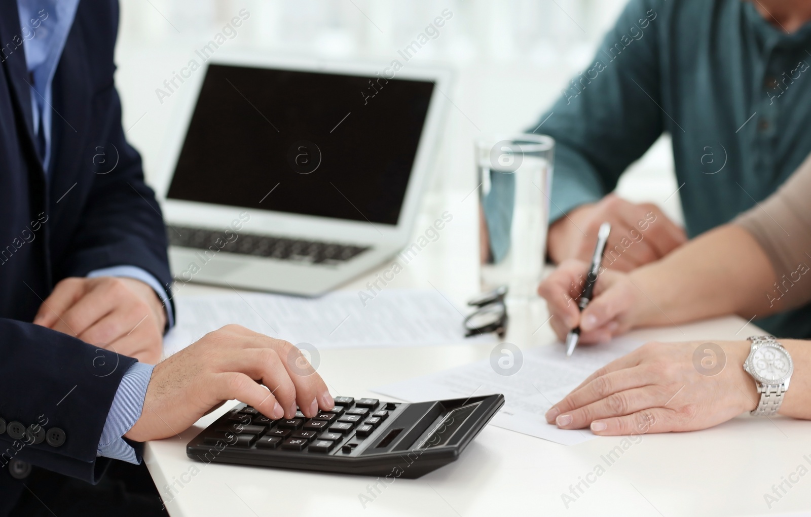 Photo of Mature couple discussing pension with consultant in office