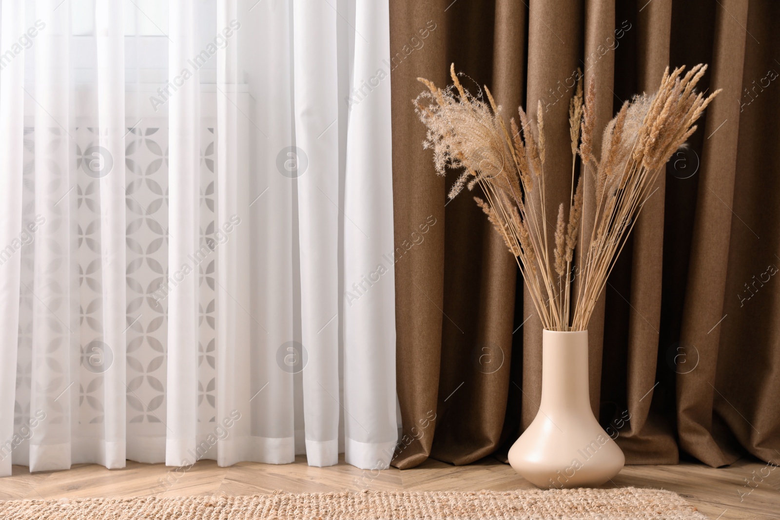 Photo of Fluffy reed plumes near window indoors, space for text. Interior element