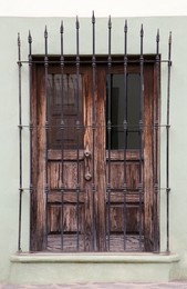 Photo of Building with wooden window and steel grilles