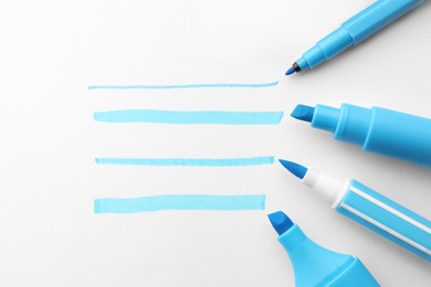 Photo of Light blue stripes drawn with markers and highlighters isolated on white, top view