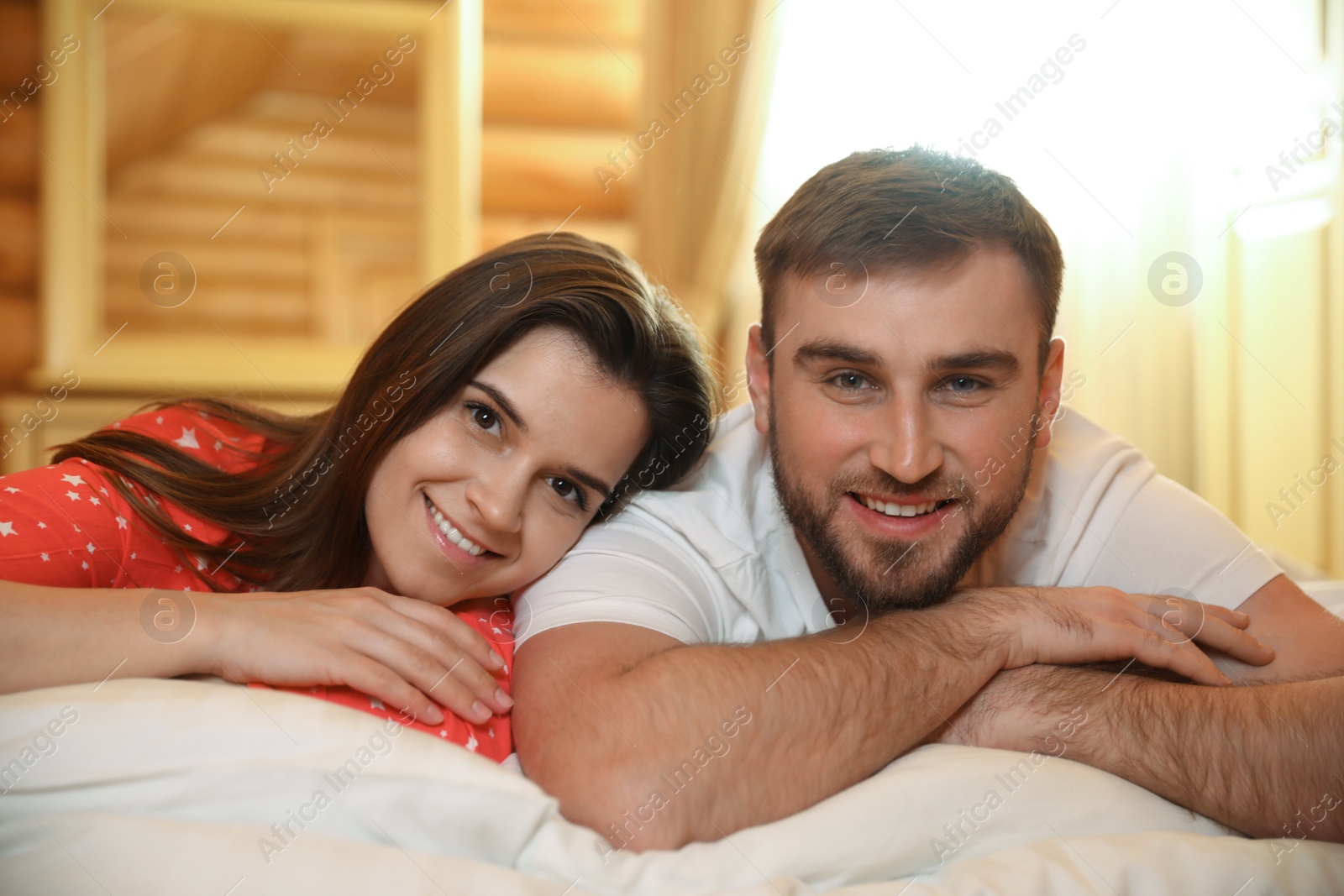 Photo of Couple lying in bed at home. Lazy morning