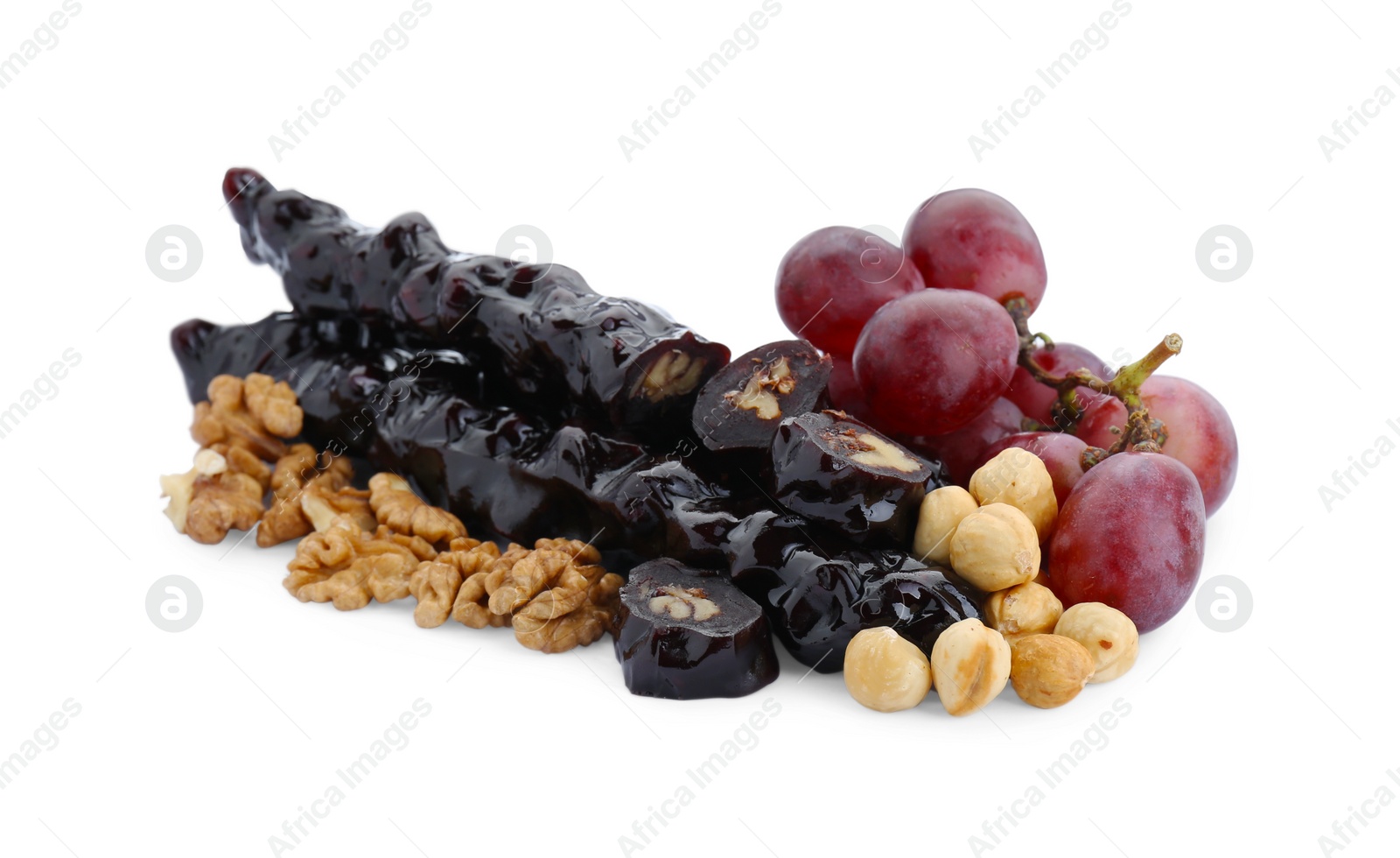 Photo of Delicious sweet churchkhelas with nuts and grapes isolated on white