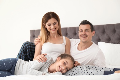 Photo of Happy family with cute child in bedroom