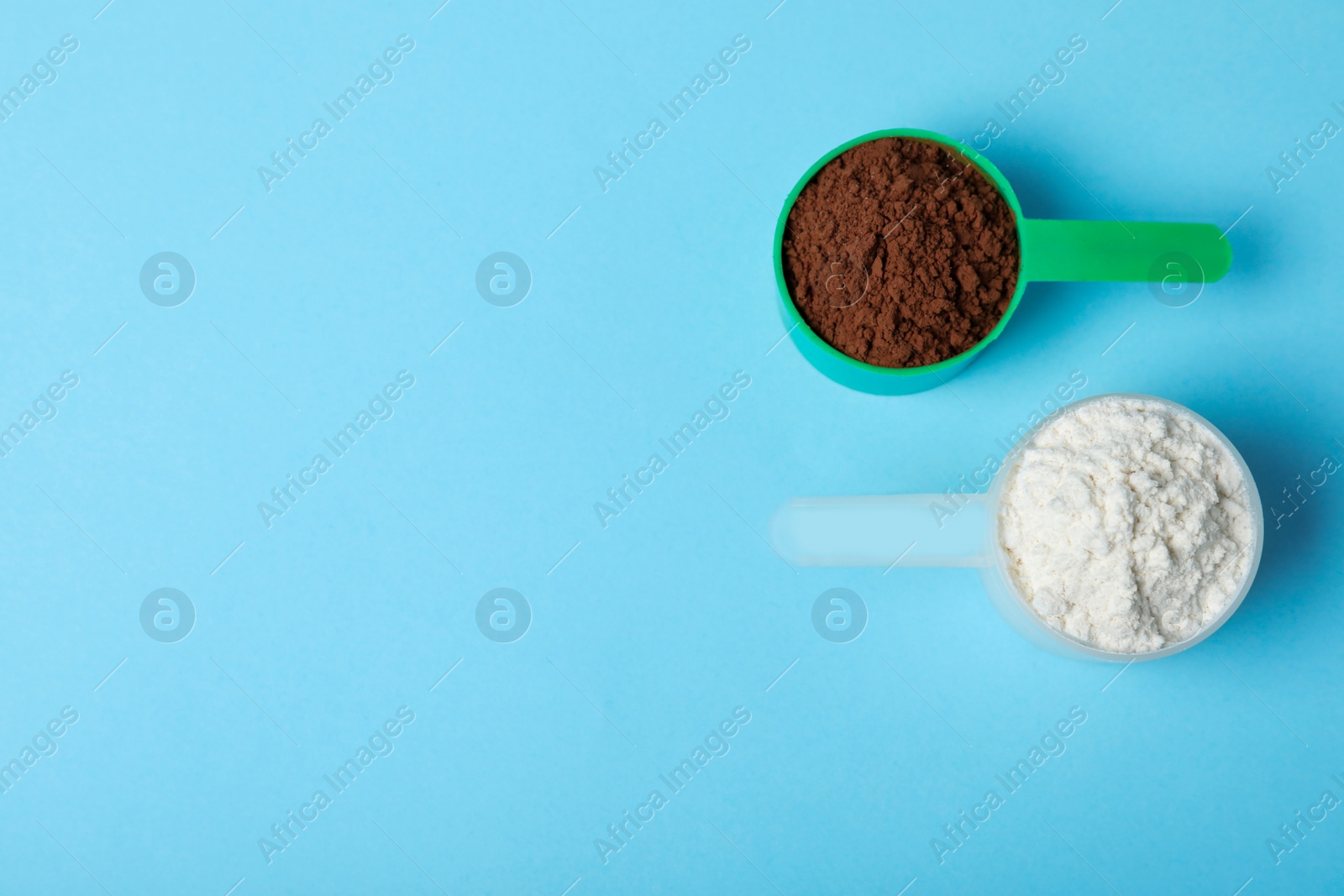 Photo of Scoops of different protein powders on light blue background, flat lay with space for text