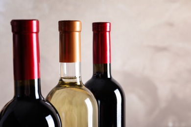 Photo of Bottles with delicious wine on light background, closeup