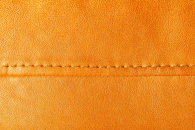 Texture of orange leather as background, closeup 