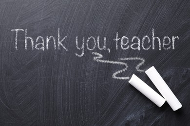 Image of Pieces of chalk and phrase Thank you, teacher written on blackboard, flat lay
