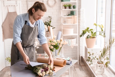 Male florist creating bouquet at workplace