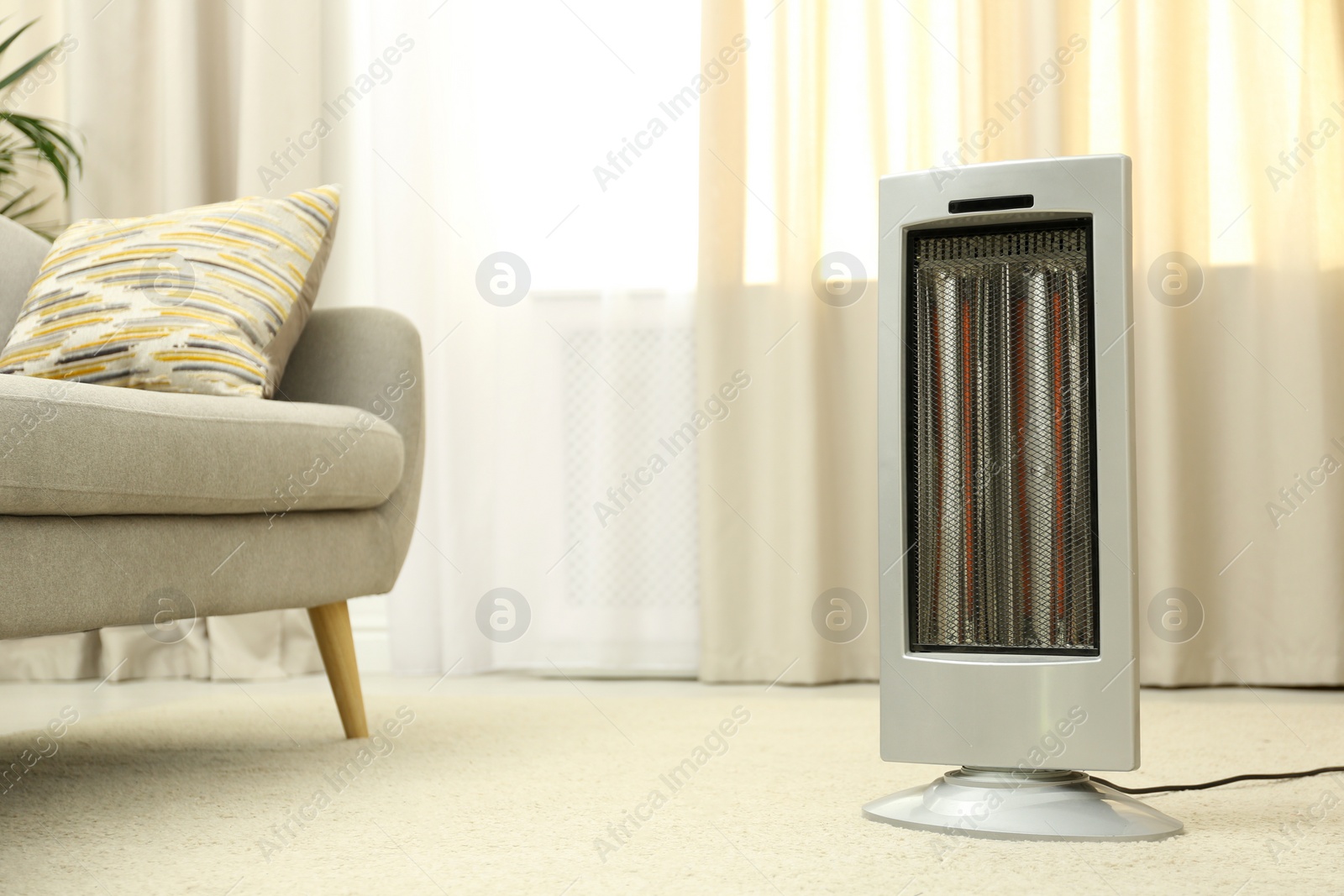 Photo of Modern electric infrared heater on floor at home. Space for text