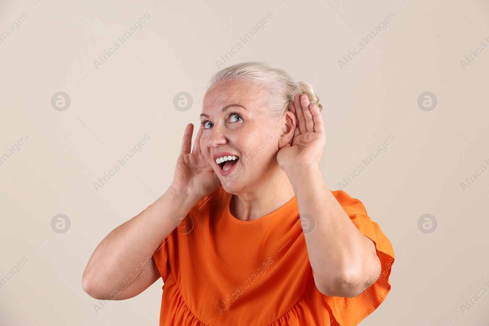 Photo of Mature woman with hearing problem on light background