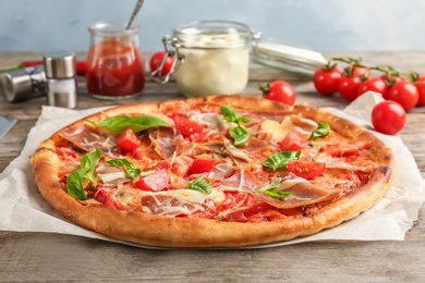 Photo of Delicious pizza with tomatoes and meat on table