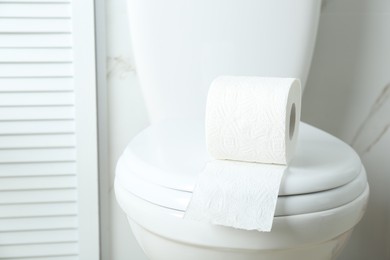 New paper roll on toilet bowl in bathroom