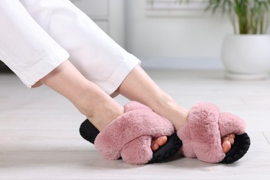 Photo of Woman in soft slippers at home, closeup