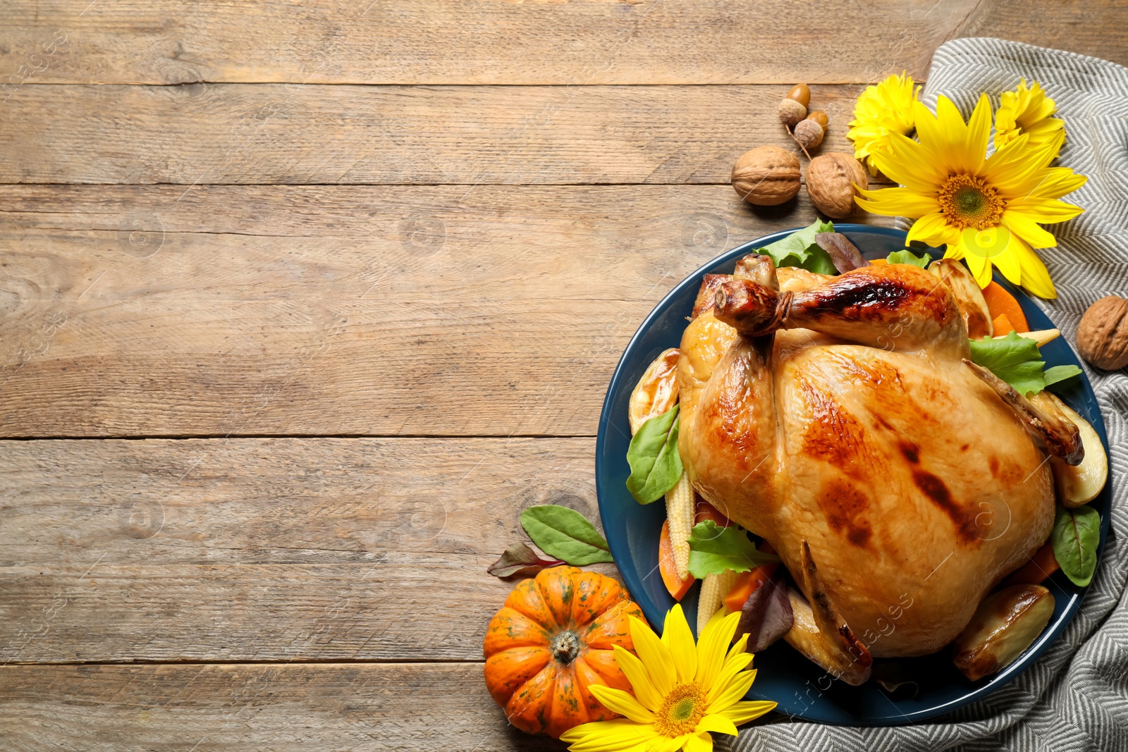 Photo of Traditional cooked turkey and autumn decor on wooden table, flat lay with space for text. Thanksgiving day celebration