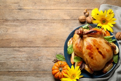 Traditional cooked turkey and autumn decor on wooden table, flat lay with space for text. Thanksgiving day celebration