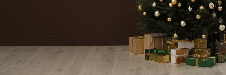 Image of Beautifully decorated Christmas tree and gift boxes indoors, space for text. Banner design