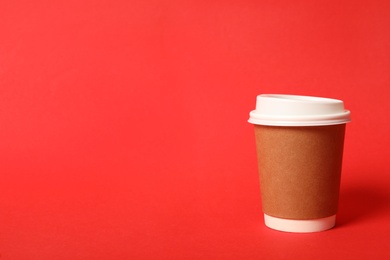 Photo of Takeaway paper coffee cup on red background. Space for text