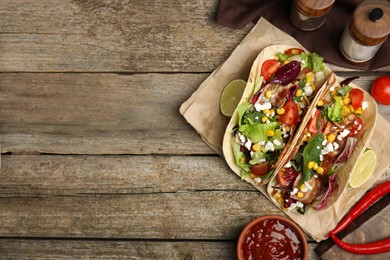 Photo of Delicious tacos with fried bacon, lime and sauce on wooden table, flat lay. Space for text