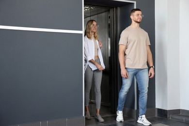 Young couple walking out of modern elevator