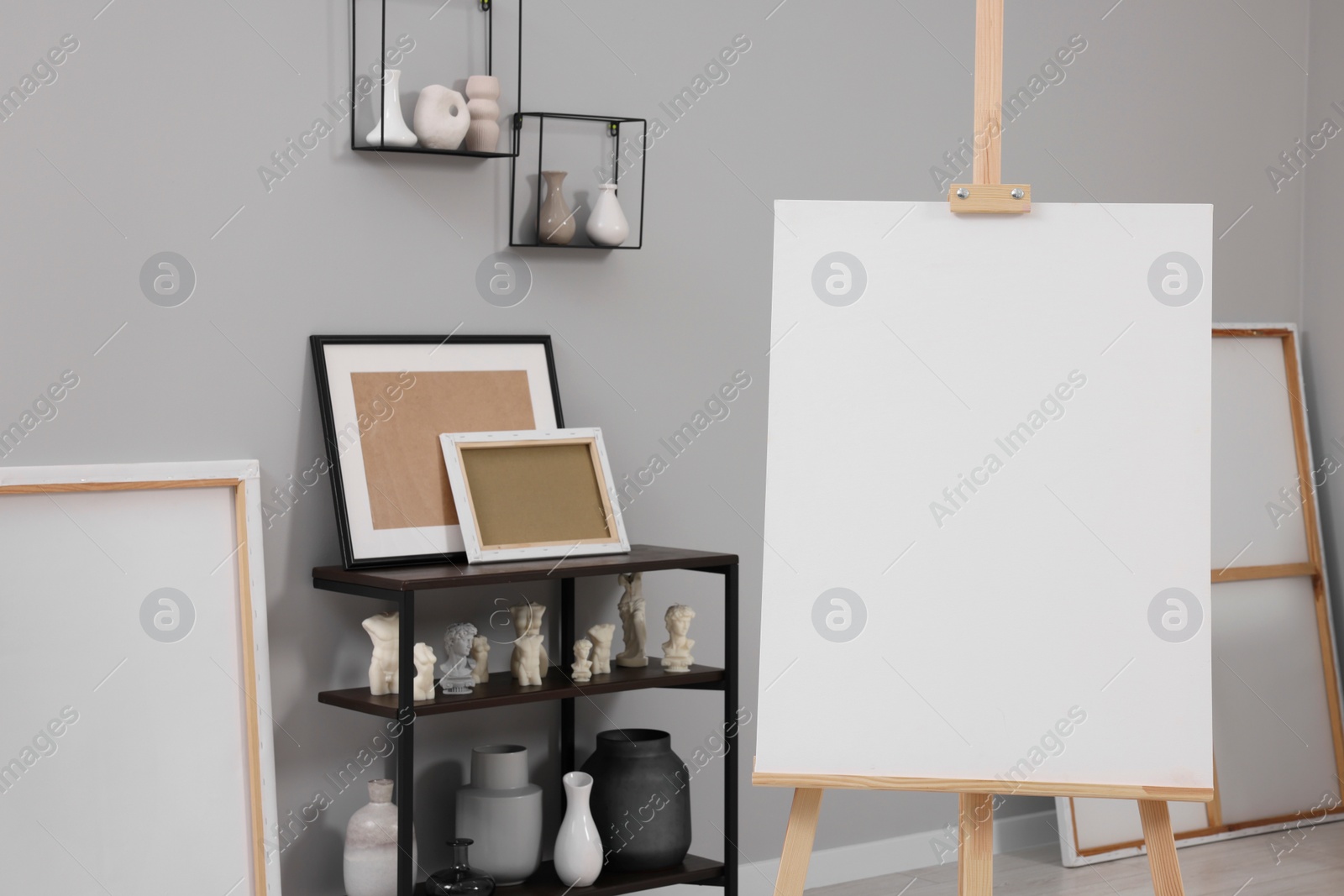 Photo of Artist's studio with easel, canvases, vases and small sculptures