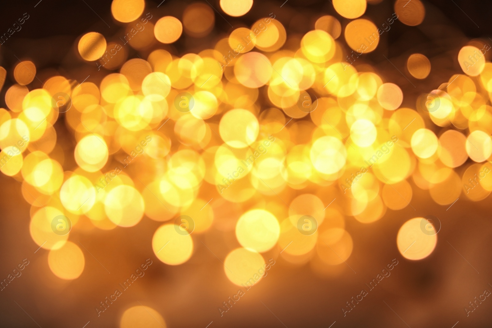 Photo of Gold glitter with bokeh effect on dark background