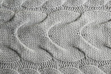 Photo of Grey knitted fabric with beautiful pattern as background, top view