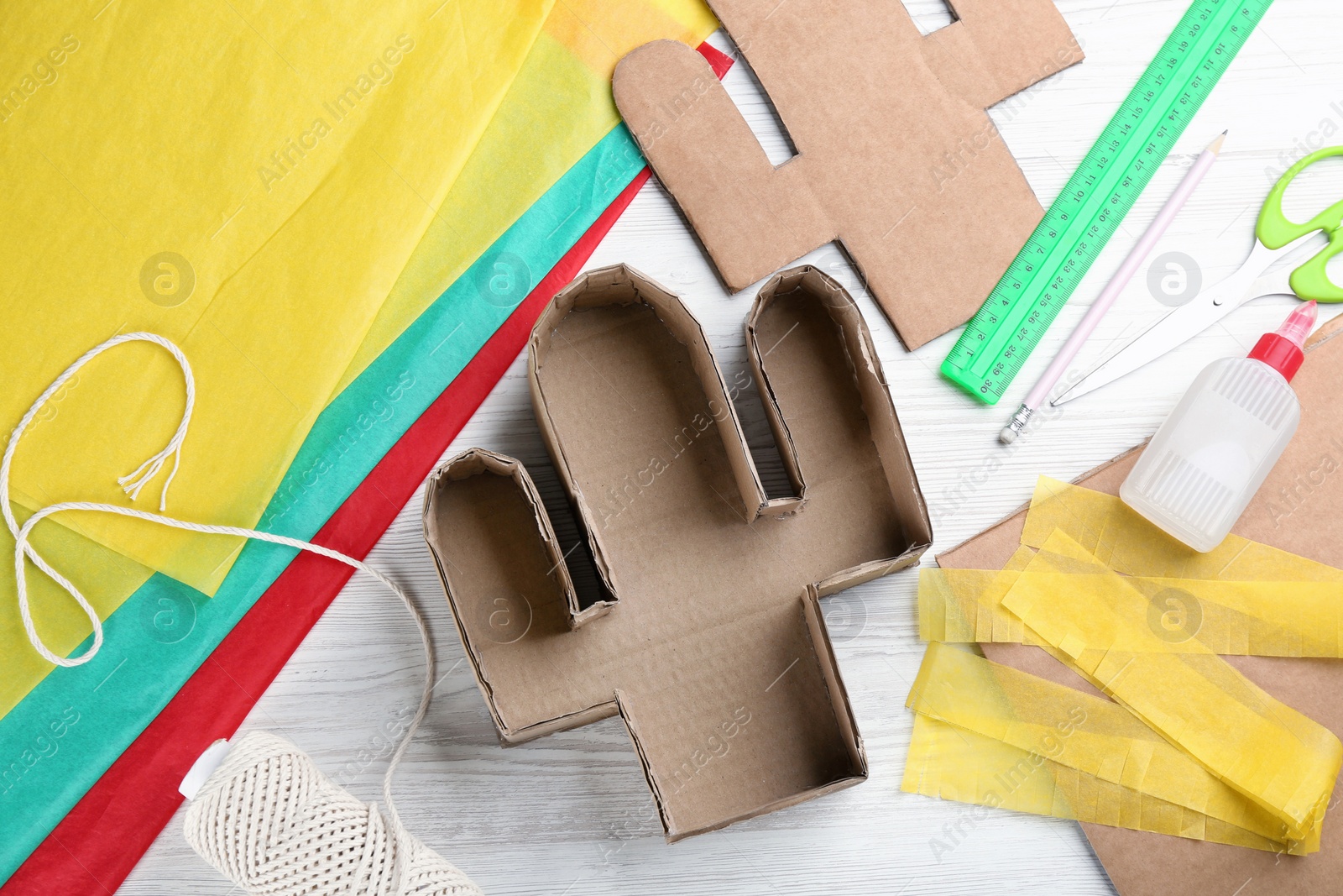 Photo of Materials and tools on white wooden table, flat lay. Cactus pinata DIY