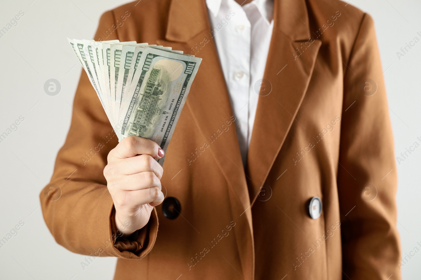 Photo of Woman holding dollar banknotes on white background, closeup. Money exchange concept