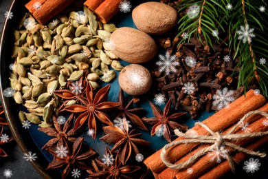 Different spices and fir tree branches on plate, top view. Cinnamon, cloves, anise, cardamom, nutmegs