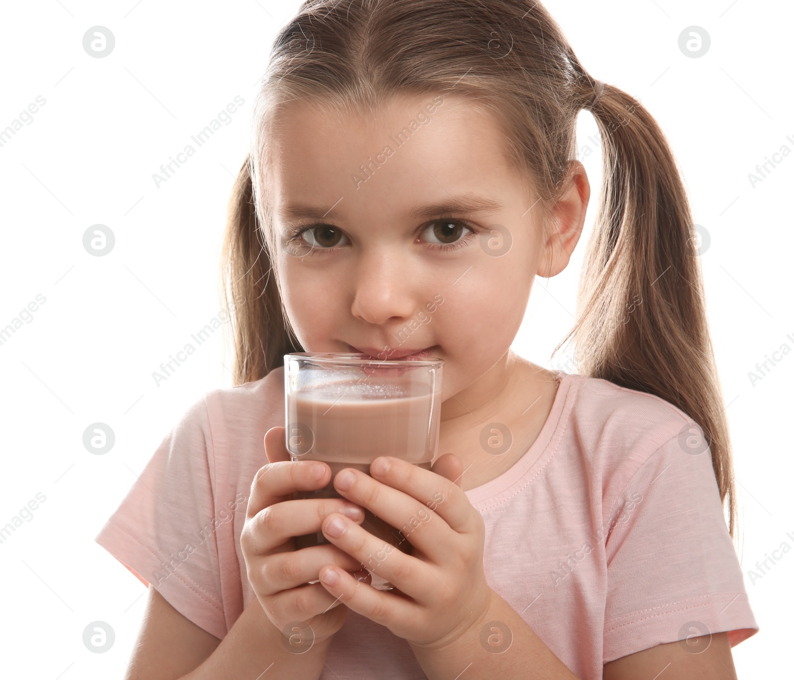Photo of Cute little child with glass of tasty chocolate milk on white background, closeup