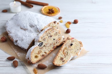 Photo of Traditional Christmas Stollen with icing sugar on white wooden table