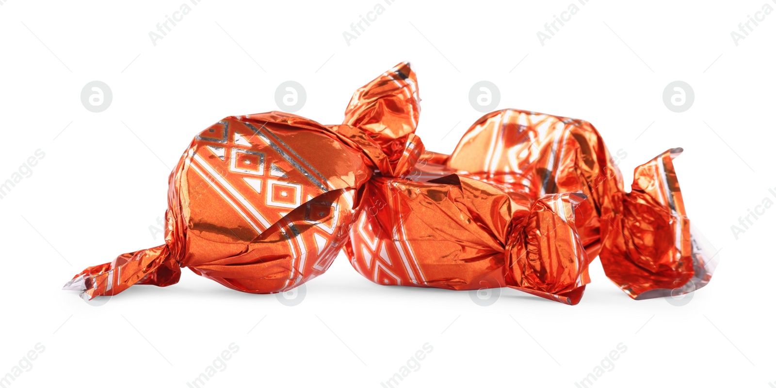 Photo of Candies in orange wrappers isolated on white