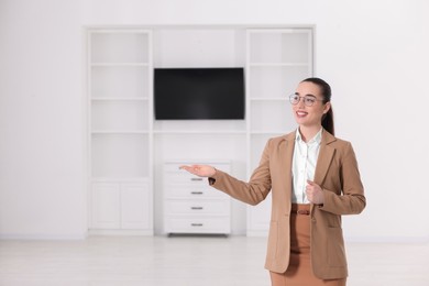 Photo of Happy real estate agent showing new house. Space for text