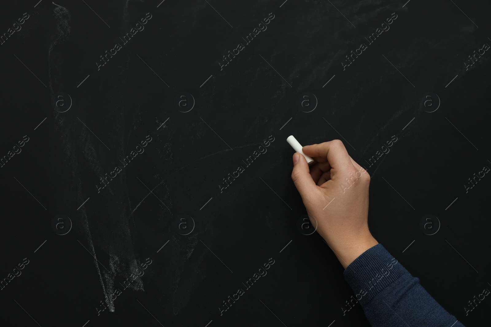 Photo of Man with white chalk near blackboard, closeup. Space for text