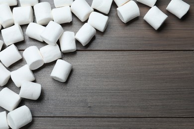 Photo of Delicious puffy marshmallows on wooden table, flat lay. Space for text