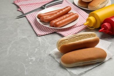 Photo of Different tasty ingredients for hot dog on light grey marble table, space for text