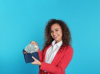 Photo of African-American businesswoman with money in wallet on color background