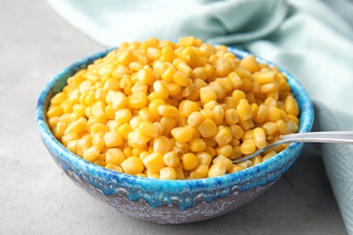 Photo of Bowl with corn kernels on grey table