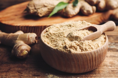 Photo of Dry ginger powder in bowl on wooden table