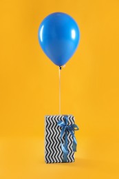 Photo of One gift box and balloon on yellow background