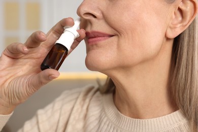 Photo of Medical drops. Woman using nasal spray indoors, closeup