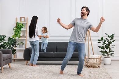 Photo of Happy family dancing and having fun in living room