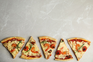 Photo of Pieces of delicious seafood pizza on grey marble table, flat lay. Space for text