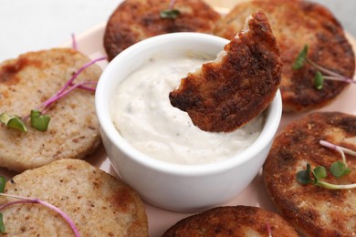 Photo of Delicious vegan cutlets and sauce on pink plate, closeup