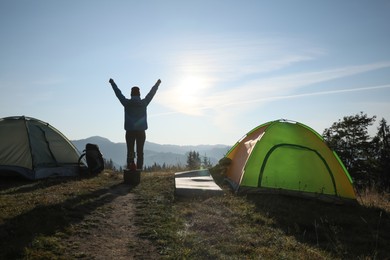 Photo of Tourist in mountain camping on sunny day, back view