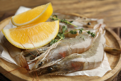 Photo of Fresh raw shrimps with lemon slices on table, closeup