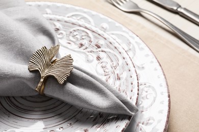 Photo of Fabric napkin and decorative ring on plate, closeup