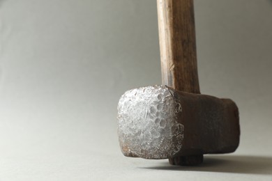 Photo of One sledgehammer on grey background, closeup. Space for text