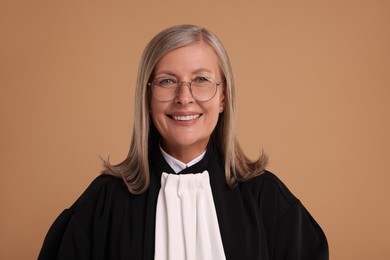 Photo of Smiling senior judge in court dress on light brown background